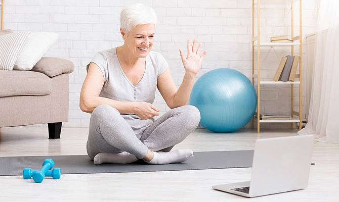 Ältere Dame beim Workout vor dem Tablet
