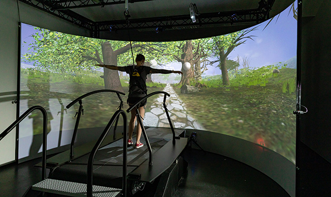 Proband geht auf dem Laufband vor einer Leinwand