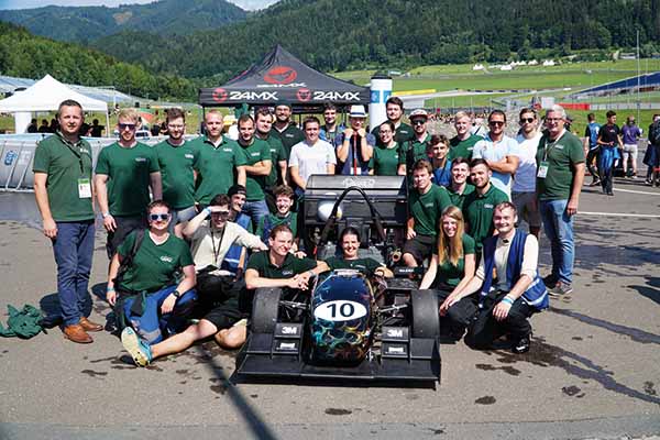 Gruppenfoto vom OS Racing Team mit Rennauto in der Mitte