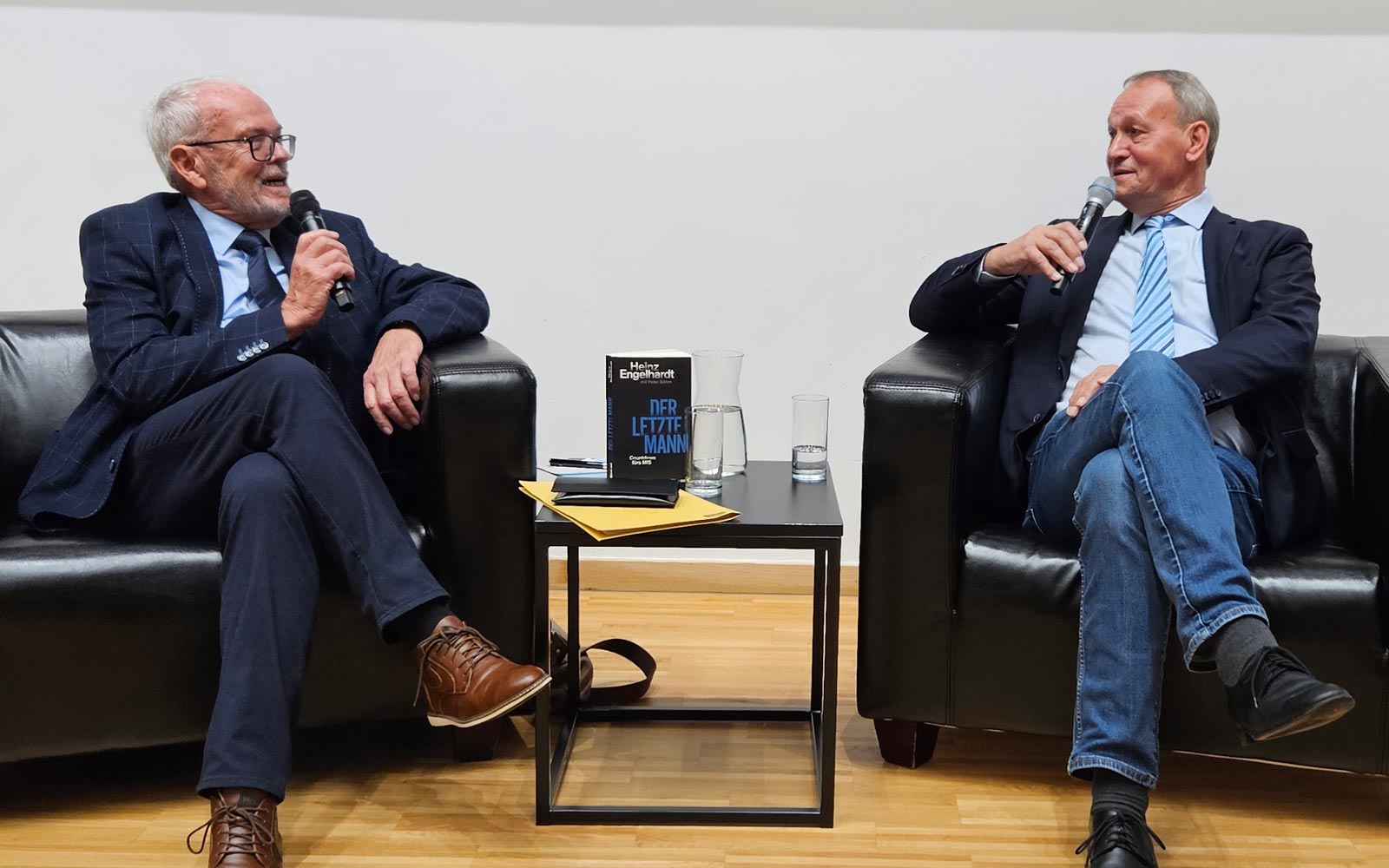 Im Gespräch nebeneinander sitzen links der ehemalige Spion Heinz Engelhardt und rechts Moderator und Lehrender Helmut Müller-Enbergs