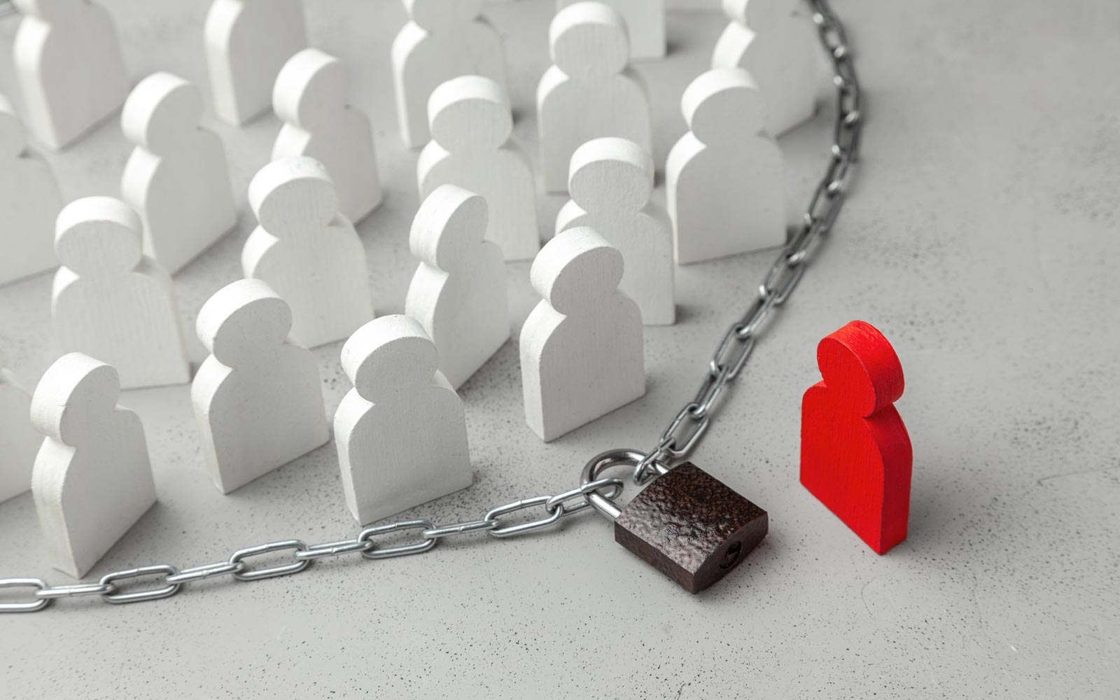 mehrere weiße Figuren stehen innerhalb einer abgeschlossenen Kette, außerhalb eine rote Figur