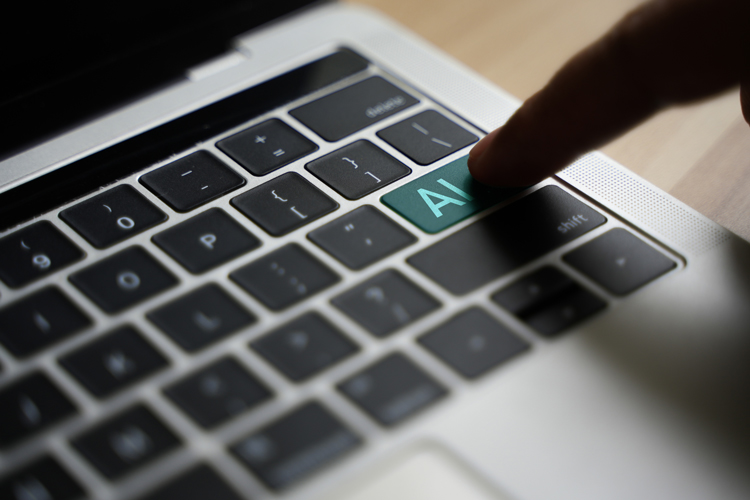 Laptoptastatur, ein menschlicher Finger drückt auf eine Taste, auf der AI steht